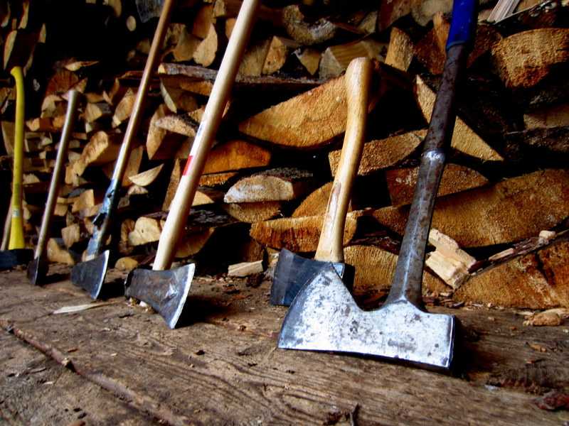 Multiple axes and wood stand on the ground in Chicago's Bad Axe